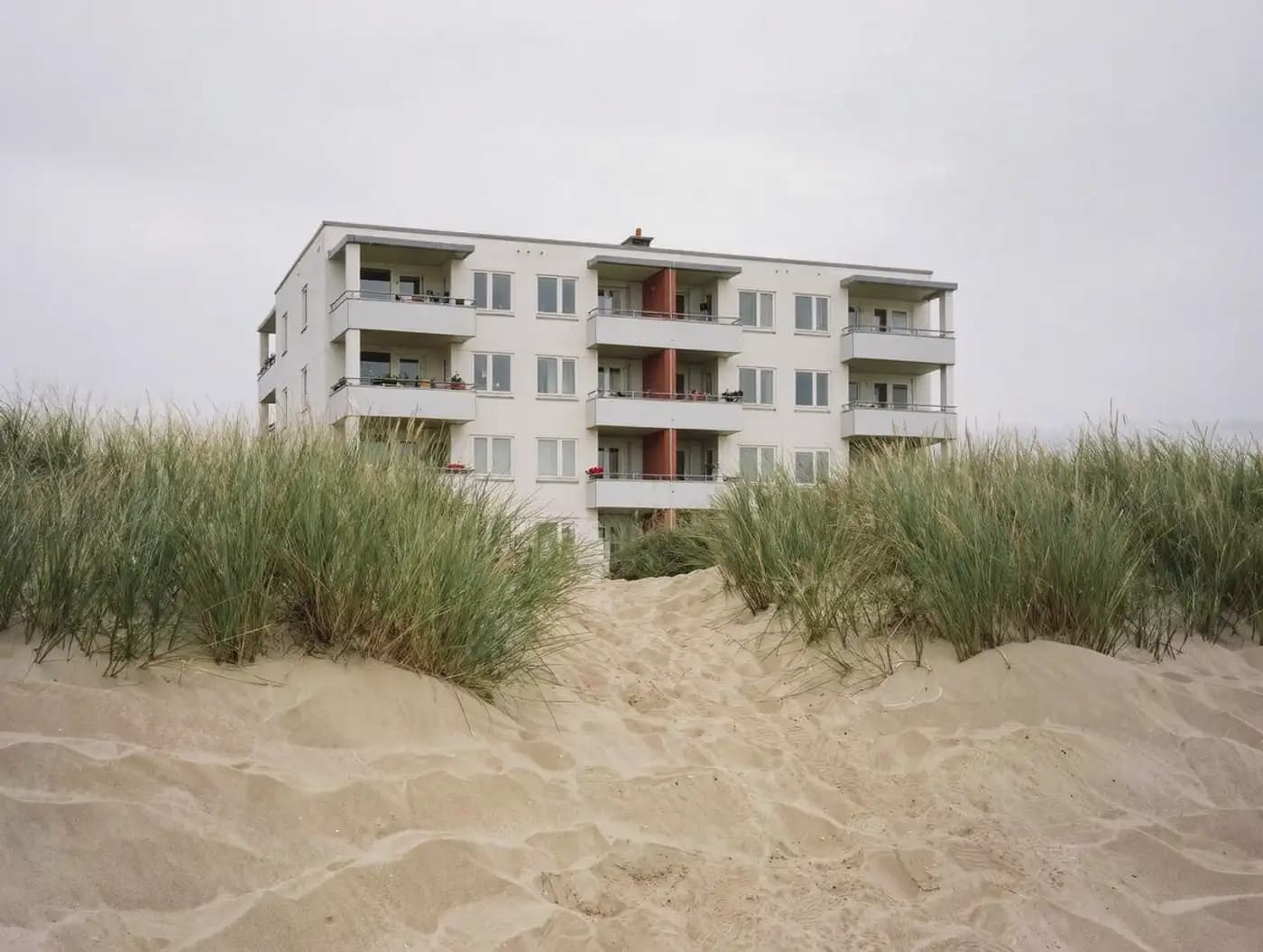 Ferienapartments an der Nordsee bei bedecktem Himmel mit Dünengras